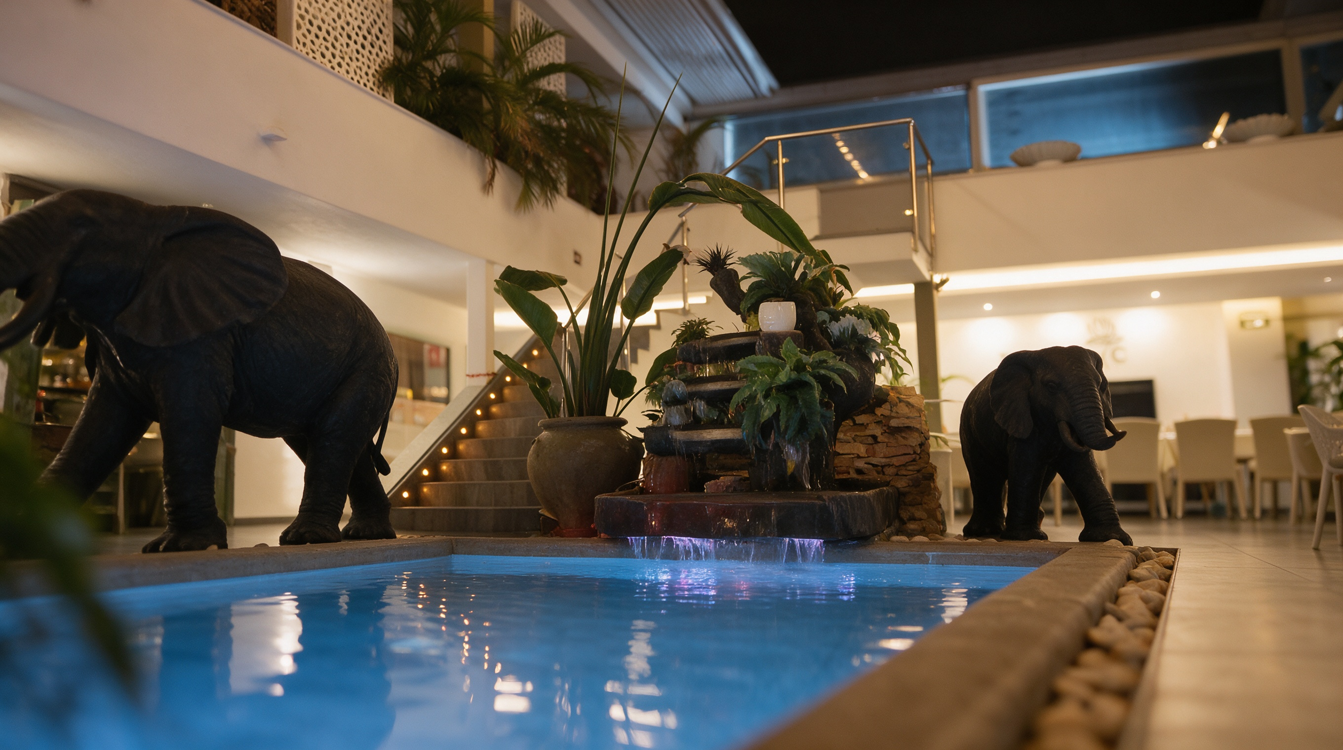 Otra角度 del patio central de Botanic, vegetación, estanque y escultura de elefante, Nerja